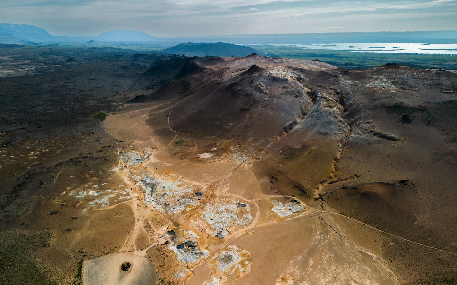 An aerial view of a desert with a mountain in the background